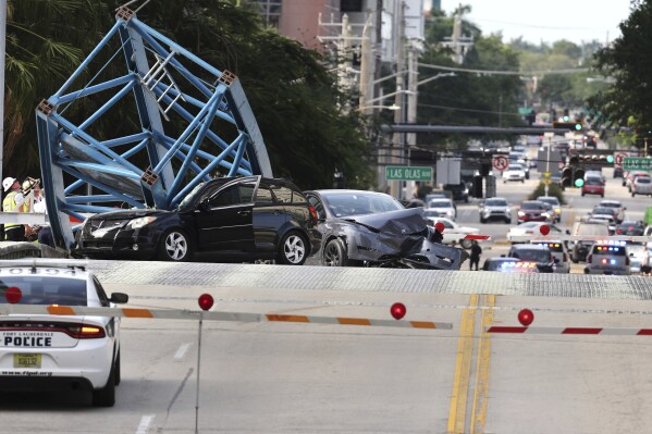 A construction worker was killed and two people were taken to the hospital after a portion of a crane dropped onto the Southeast Third Avenue bridge over the New River in downtown Fort Lauderdale, Fla., Thursday afternoon, April 4, 2024. (Carline Jean/South Florida Sun-Sentinel via AP)