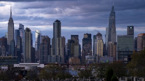 FILE - The sun sets behind the New York skyline, Sunday, Nov. 13, 2022, as seen from Calvary Cemetery. New York will move forward with its first-in-the-nation plan to charge drivers extra in tolls to enter the core of New York City, part of an effort to reduce congestion, improve air quality and raise funds for the city's public transit system. The program is expected to begin in spring of 2024. (AP Photo/Julia Nikhinson, File)