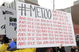 FILE - In this Jan. 20, 2018 file photo, a marcher carries a sign with the popular Twitter hashtag #MeToo used by people speaking out against sexual harassment as she takes part in a Women's March in Seattle.  According to a study published Monday, Sept. 16, 2019, the first sexual experience for many U.S. women was forced or coerced intercourse in their early teens, encounters that for some may have had lasting health repercussions. (AP Photo/Ted S. Warren, File)