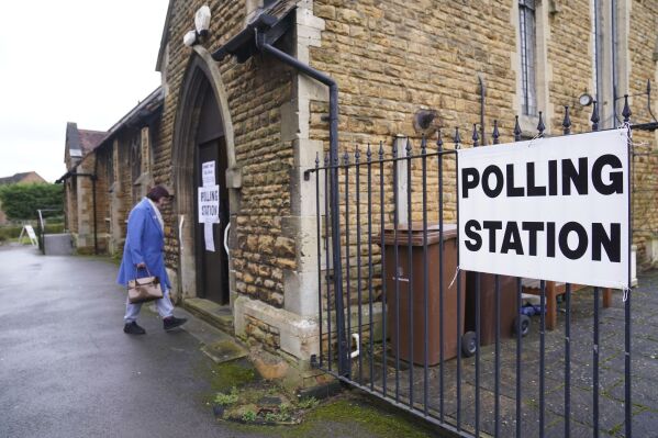 People arrive at St Peter's Church Hall as voting gets underway in the Wellingborough by-election, which was triggered by the recall of MP Peter Bone, in Rushden, England, Thursday Feb. 15, 2024. (Joe Giddens/PA via AP)
