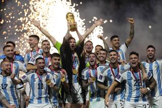 FILE - Argentina's Lionel Messi lifts the trophy after winning the World Cup final soccer match between Argentina and France at the Lusail Stadium in Lusail, Qatar, Sunday, Dec. 18, 2022. The World Cup group stage format for 2026 was changed to 12 groups of four teams from 16 groups of three teams by FIFA’s Council on Tuesday, March 14, 2023. (AP Photo/Martin Meissner, File)