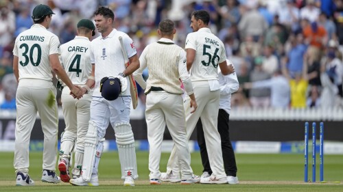 England's James Anderson, center, shakes hands to congratulate Australia's captain Pat Cummins, left, on their win in the second Ashes Test match between England and Australia, at Lord's cricket ground in London, Sunday, July 2, 2023. (AP Photo/Kirsty Wigglesworth)