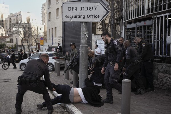 FILE - Israeli police officers scuffle with ultra-Orthodox Jewish men during a protest against possible changes to the military draft laws, outside a military recruitment office in Jerusalem, on March 4, 2024. (AP Photo/Leo Correa, File)