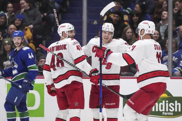 Carolina Hurricanes' Jordan Staal (11) celebrates his empty net goal during  the third period of an NHL hockey game against the Boston Bruins with  teammates Jordan Martinook, center, and Carolina Hurricanes' Brady
