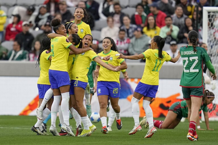 Players from Brazil, right, celebrate a goal from Brazil's Antonia during the first half of a CONCACAF Gold Cup women's soccer tournament semifinal match against Mexico, Wednesday, March 6, 2024, in San Diego. (AP Photo/Gregory Bull)
