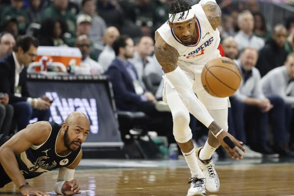 Los Angeles Clippers' Robert Covington (23) chases down a loose ball against Milwaukee Bucks' Jevon Carter during the first half of an NBA basketball game Friday, April 1, 2022, in Milwaukee. (AP Photo/Jeffrey Phelps)