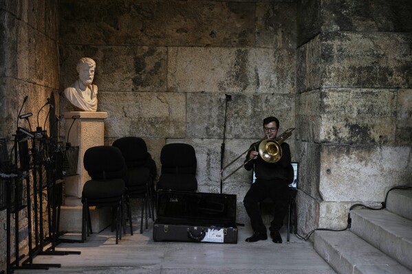 Greek National Opera musician Neoklis Aravantinos plays his bass trombone ahead of Giacomo Puccini's "Turandot" premiere during the 70th Athens Epidaurus Festival at the Odeon of Herodes Atticus in Athens, Greece, Sunday, June 1, 2025. (AP Photo/Thanassis Stavrakis)