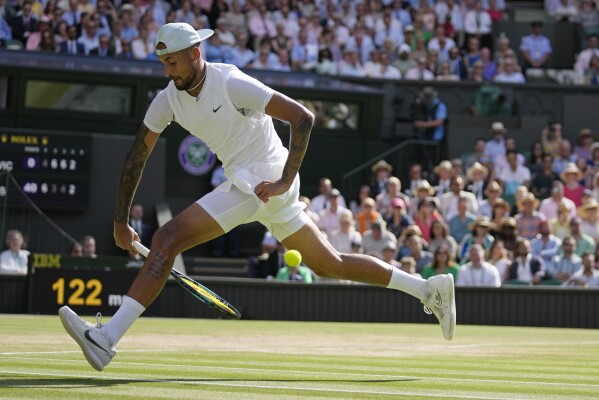 Australia's Nick Kyrgios returns the ball from between his legs to Serbia's Novak Djokovic in the final of the men's singles on day fourteen of the Wimbledon tennis championships in London, Sunday, July 10, 2022. (AP Photo/Alastair Grant, File)