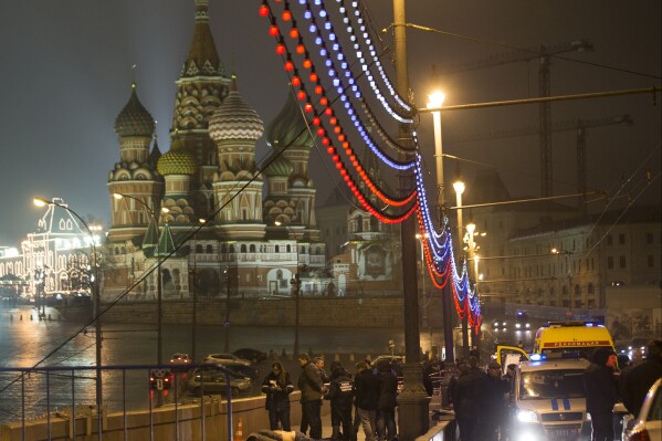 FILE - Russian police surround the body of Boris Nemtsov, a charismatic former deputy prime minister who was shot to death on a bridge just off Red Square, with St. Basil Cathidral in the background, in Moscow, Russia on Saturday, Feb. 28, 2015. His death brought thousands into the streets of Moscow, where they were allowed to protest unimpeded by police – unlike after the scene after the Feb. 16, 2024, death in prison of Alexei Navalny, a political foe of President Vladimir Putin. Mourners trying to lay flowers at makeshift memorials to Navalny were quickly arrested. (AP Photo/Pavel Golovkin, File)