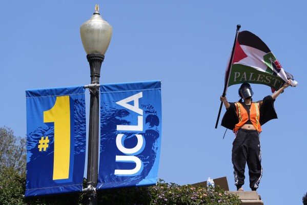 FILE - Demonstrators wave flags on the UCLA campus, after nighttime clashes between Pro-Israel and Pro-Palestinian groups, May 1, 2024, in Los Angeles. If the University of California, one of the largest public university systems in the country, were to agree to divestment calls from students protesting the Israel-Hamas war, the system would lose $32 billion of its overall $175 billion in assets, officials said on Tuesday, May 15, 2024. (AP Photo/Jae C. Hong, File)