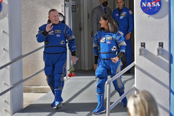 NASA astronauts Butch Wilmore, left, and Suni Williams share a laugh as they leave the operations and checkout building for a trip to launch pad at Space Launch Complex 41 Saturday, June 1, 2024, in Cape Canaveral, Fla. The two astronauts are scheduled to liftoff later today on the Boeing Starliner capsule for a trip to the international space station. . (AP Photo/John Raoux)