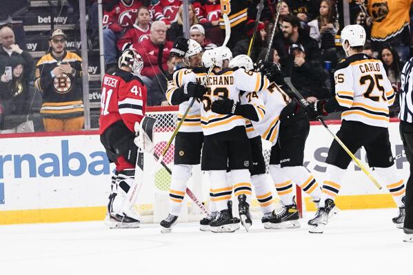 New Jersey Devils goaltender Vitek Vanecek (41) reacts as the Boston Bruins celebrate a goal by Patrice Bergeron (37) during the third period of an NHL hockey game Wednesday, Dec. 28, 2022, in Newark, N.J. The Bruins won 3-1. (AP Photo/Frank Franklin II)