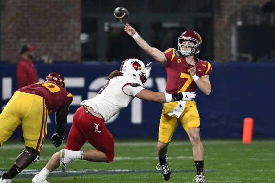 Southern California quarterback Miller Moss (7) throws a pass under pressure from Louisville defensive lineman Ashton Gillotte (9) during the second half of the Holiday Bowl NCAA college football game Wednesday, Dec. 27, 2023, in San Diego. (AP Photo/Denis Poroy)