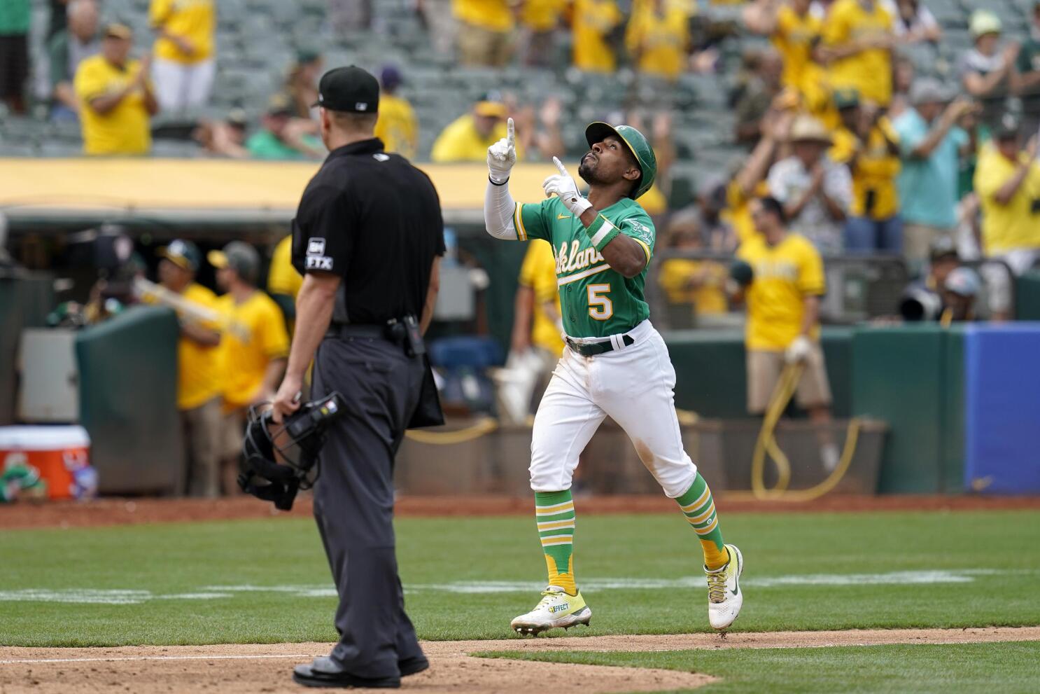 Oakland As Rickey Henderson holds third base over his head after