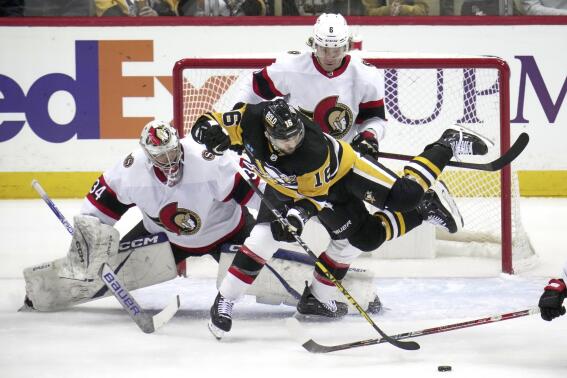 Pittsburgh Penguins' Jason Zucker (16) is checked to the ice by Ottawa Senators' Jakob Chychrun (6) in front of goaltender Dylan Ferguson (34) during the first period of an NHL hockey game in Pittsburgh, Monday, March 20, 2023. (AP Photo/Gene J. Puskar)