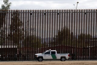 FILE - In this April 5, 2019, file photo, a U.S. Customs and Border Protection vehicle sits near the wall as President Donald Trump visits a new section of the border wall  with Mexico in El Centro, Calif. A federal judge has denied a request by the U.S. House of Representatives to prevent President Donald Trump from tapping Defense Department money for a border wall with Mexico. (AP Photo/Jacquelyn Martin, File)