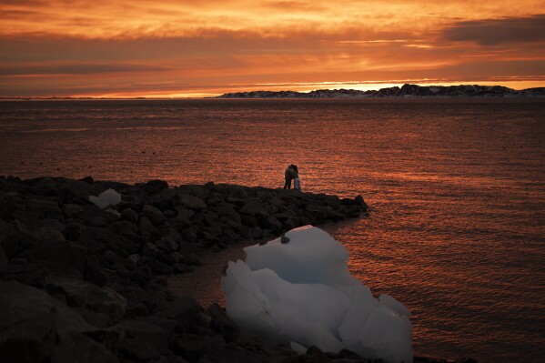 Ana, 18, and Victor, 19, embrace as they watch the sunset in Nuuk, Greenland, Sunday, Feb. 16, 2025. (AP Photo/Emilio Morenatti)
