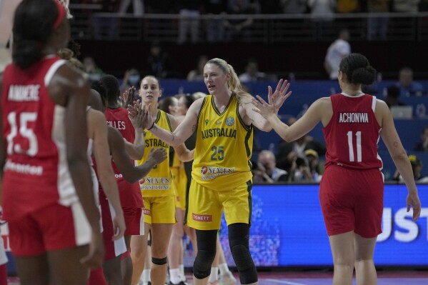 FILE - Australia's Lauren Jackson, second right, shakes hands with Canadian players after winning their bronze medal game at the women's Basketball World Cup in Sydney, Australia, Saturday, Oct. 1, 2022. Jackson returned to international play at the 2022 World Cup to lead the Opals to the bronze medal. The 43-year-old three-time WNBA MVP hasn't played in the Olympics since 2012 because of injuries. (Ǻ Photo/Rick Rycroft, File)