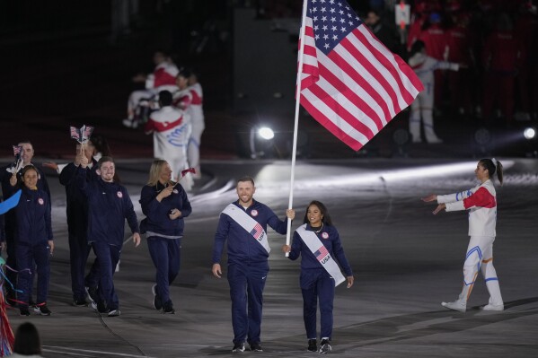 Jordan Chiles and Vincent Hancock of the United States carry their country's flag during the opening ceremony of the Pan American Games at the National Stadium in Santiago, Chile, Friday, Oct. 20, 2023. (AP Photo/Silvia Izquierdo)