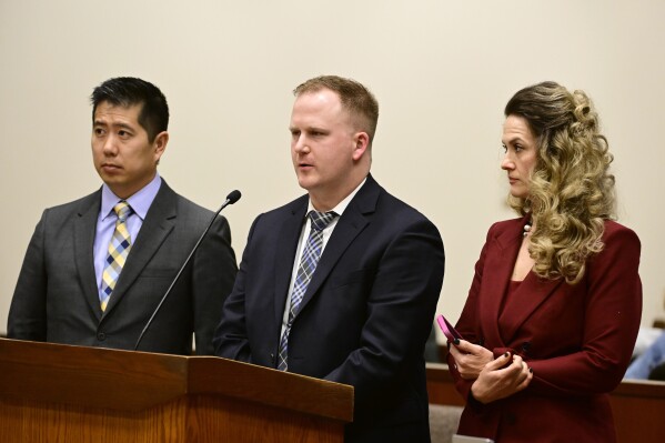 FILE - Aurora, Colo., Police Officer Nathan Woodyard, center, is flanked by his lawyers, Andrew Ho, left, and Megan Downing, right, during an arraignment after being charged in the 2019 death of Elijah McClain at the Adams County Justice Center, Jan. 20, 2023, in Brighton, Colo. Woodyard testified Wednesday, Nov. 1, that he had feared for his life when he applied a neck hold on the 23-year-old Black man before paramedics injected McClain with a fatal overdose of ketamine. (Andy Cross/The Denver Post via AP, File)