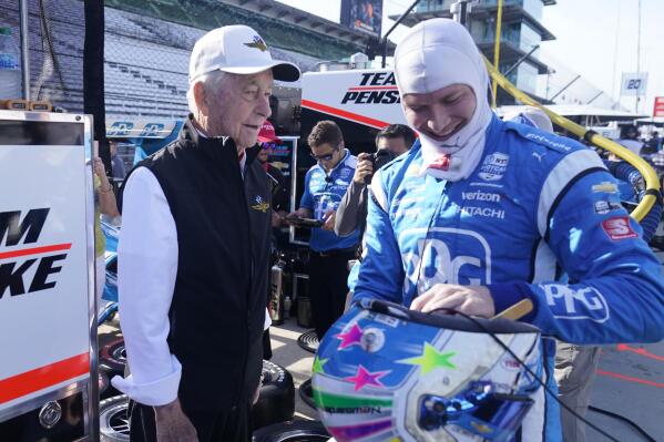 Roger Penske talks with Josef Newgarden before a practice session for the IndyCar auto race at Indianapolis Motor Speedway, Friday, July 29, 2022, in Indianapolis. (AP Photo/Darron Cummings)