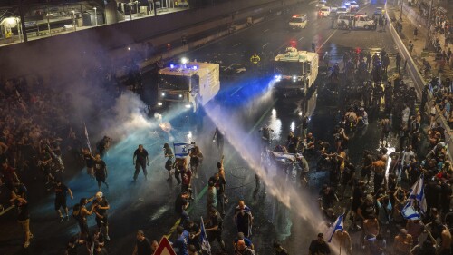 Riot police tries to clear demonstrators with a water canon during a protest against plans by Netanyahu's government to overhaul the judicial system, in Tel Aviv, Monday, July 24, 2023. Israeli lawmakers on Monday approved a key portion of Prime Minister Benjamin Netanyahu's divisive plan to reshape the country's justice system despite massive protests that have exposed unprecedented fissures in Israeli society. (AP Photo/Oded Balilty)