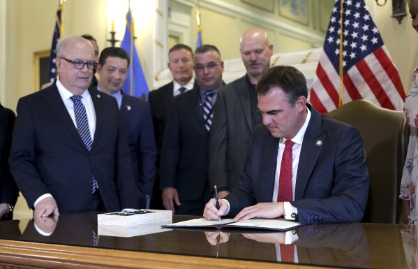 Oklahoma Gov. Kevin Stitt signs an executive order in the Blue Room at the state Capitol in Oklahoma City, Wednesday, Dec. 13, 2023. In Oklahoma, Republican Gov. Kevin Stitt signed an executive order in December barring state agencies and universities from spending money diversity initiatives. (Sarah Phipps/The Oklahoman via 麻豆传媒app)