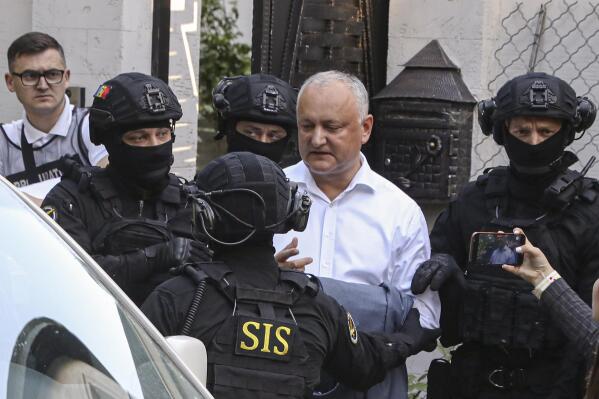 Members of Moldova's Information and Security service (SIS) escort former Moldovan President Igor Dodon to a van after he was detained at his house in Chisinau, Moldova, Tuesday, May 24, 2022. Moldovan media reported that police were conducting a search of a house described as belonging to Dodon, who served as president from 2016 to 2020. (AP Photo/Aurel Obreja)