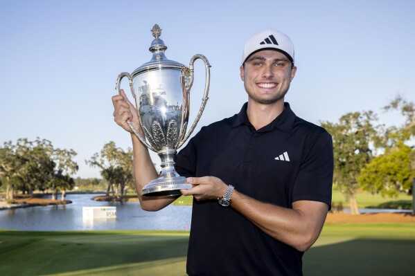 Ludvig Åberg, of Sweden, holds the trophy after the final round of the RSM Classic golf tournament, Sunday, Nov. 19, 2023, in St. Simons Island, Ga. (AP Photo/Stephen B. Morton)