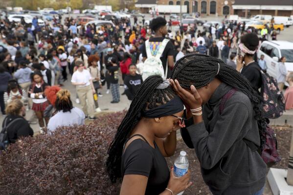 Students stand in a parking lot near the Central Visual & Performing Arts High School after a reported shooting at the school in St. Louis on Monday, Oct. 24, 2022. (David Carson/St. Louis Post-Dispatch via AP)