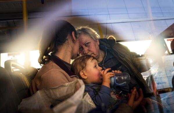 People with children wait after arriving from the Ukrainian city of Mariupol at a center for displaced people in Zaporizhzhia, Ukraine, Tuesday, May 3, 2022. (AP Photo/Evgeniy Maloletka)