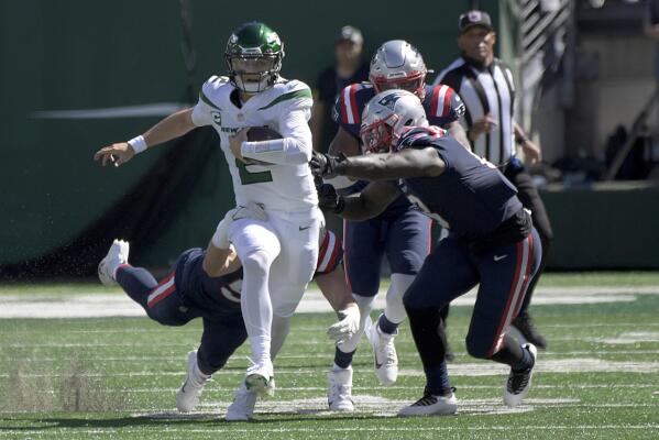 New York Jets quarterback Zach Wilson (2), left, scrambles for a first down during the second half of an NFL football game against the New England Patriots, Sunday, Sept. 19, 2021, in East Rutherford, N.J. (AP Photo/Bill Kostroun)