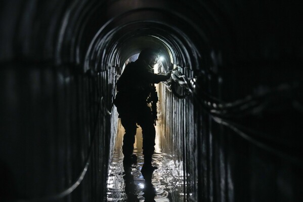 Lt. Col. Ido, whose last name was redacted by the military, walks inside a tunnel underneath the UNRWA compound, where the military discovered tunnels in the main headquarters of the U.N. agency that the military says Hamas militants used to attack its forces during a ground operation in Gaza, Thursday, Feb. 8, 2024. The Israeli military says it has discovered tunnels underneath the main headquarters of the U.N. agency for Palestinian refugees in Gaza City, alleging that Hamas militants used the space as an electrical supply room. The unveiling of the tunnels marked the latest chapter in Israel's campaign against the embattled agency, which it accuses of collaborating with Hamas. (APPhoto/Ariel Schalit)