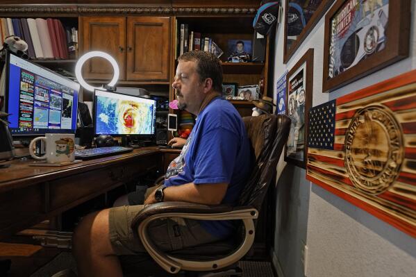 MIke Boylan is shown at his home office Tuesday, Oct. 5, 2021, in Oldsmar, Fla. As Hurricane Ida barreled toward Louisiana last August, Boylan hit the road with live reports for his social media followers as he chased the storm. (AP Photo/Chris O'Meara)