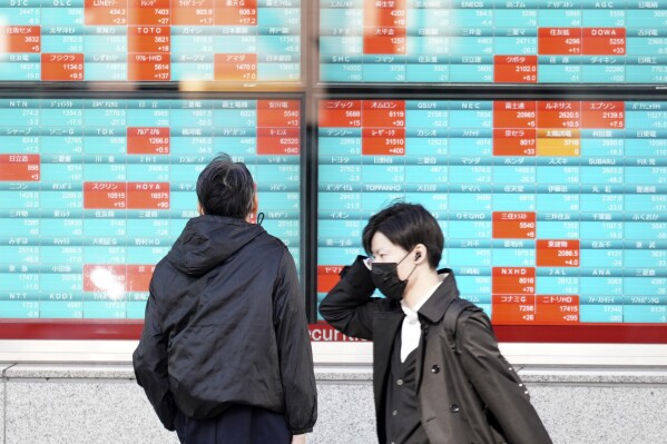 FILE - A person looks at an electronic stock board showing Japan's Nikkei 225 index at a securities firm Wednesday, Nov. 29, 2023, in Tokyo. Asian markets were steady in holiday-thinned trading on Tuesday, Dec. 26, 2023, with some markets in the region closed for holidays.(AP Photo/Eugene Hoshiko)