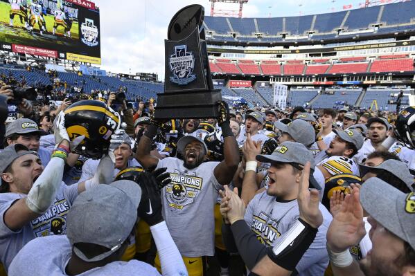 Iowa defensive back Dallas Craddieth, center, holds up the trophy as he celebrates with teammates after they defeated Kentucky in the Music City Bowl NCAA college football game Saturday, Dec. 31, 2022, in Nashville, Tenn. (AP Photo/Mark Zaleski)