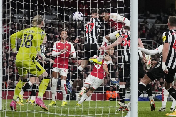 Newcastle's goalkeeper Loris Karius, left, misses the opening own goal by Newcastle's Sven Botman after Arsenal's Gabriel, top right, shoots on goal during the English Premier League soccer match between Arsenal and Newcastle United at the Emirates stadium in London, England, Saturday, Feb. 24, 2024. (AP Photo/Alastair Grant)