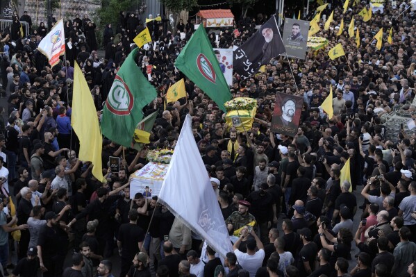 Hezbollah fighters carry the coffins of four fallen comrades during their funeral procession in the southern suburb of Beirut, Lebanon, Wednesday, Sept. 18, 2024. (AP Photo/Bilal Hussein)
