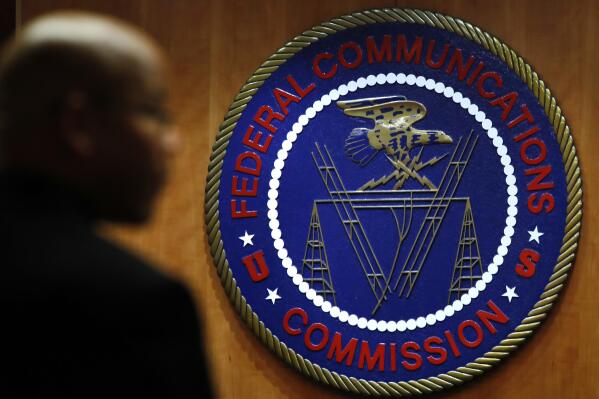 FILE- This Dec. 14, 2017, file photo, shows the seal of the Federal Communications Commission (FCC) before a meeting in Washington.  Congressional leaders and a media accountability organization are urging the Federal Communications Commission to examine how policy decisions have disparately harmed Black people and other communities of color, according to a letter sent Tuesday, June 29, 2021, to the acting FCC chair.  (AP Photo/Jacquelyn Martin, File)