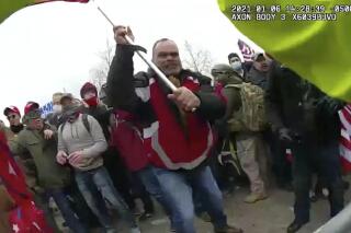 FILE - This still frame from Metropolitan Police Department body worn camera video shows Thomas Webster, in red jacket, at a barricade line at on the west front of the U.S. Capitol on Jan. 6, 2021, in Washington. Jurors have returned to court to deliberate in the federal trial of a New York Police Department veteran charged with assaulting an officer who tried to protect the Capitol from an attacking insurrectionist mob last year. Retired NYPD officer Thomas Webster is the first Capitol riot defendant to be tried on an assault charge and the first to present a jury with a self-defense argument. (Metropolitan Police Department via AP, File)