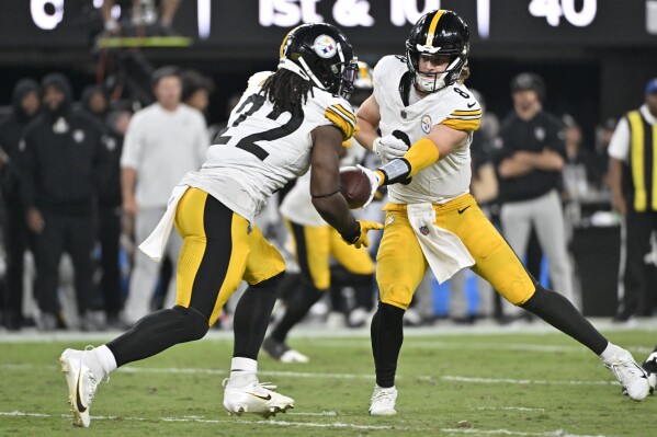 Pittsburgh Steelers quarterback Kenny Pickett, right, hands off to running back Najee Harris (22) during the first half of an NFL football game against the Las Vegas Raiders Sunday, Sept. 24, 2023, in Las Vegas. (AP Photo/David Becker)