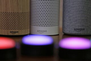 FILE - Amazon Echo and Echo Plus devices, behind, sit near illuminated Echo Button devices during an event announcing several new Amazon products by the company, Sept. 27, 2017, in Seattle. Amazon is cutting hundreds of jobs in the unit that handles Alexa, its popular voice assistant. In a note to employees on Friday, Nov, 17, 2023, Daniel Rausch, Amazon’s vice president of Alexa and Fire TV, wrote the company was eliminating certain roles because it was ditching some initiatives. (AP Photo/Elaine Thompson, File)