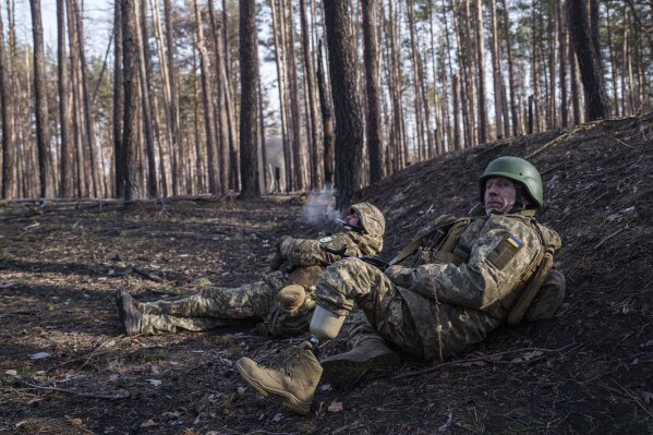 Andrii Serhieiev, foreground, a Ukrainian soldier with the 53rd brigade who lost a leg in battle, works with another soldier to detonate unexploded ordnance near the front line in Ukraine's Donetsk region on Feb. 13, 2025. (AP Photo/Evgeniy Maloletka)