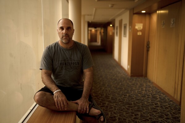 Nir Shani, a 46-year old physical therapist from Kibbutz Be'eri, poses for a portrait at the Dead Sea hotel where he is sheltering with five family members, waiting for word on Amit, his 16-year-old son held hostage in Gaza, in Ein Bokek, Israel, Sunday, Israel, Oct. 22, 2023. Two weeks after Hamas militants gunned down 10 percent of their community, torturing scores of people and kidnapping many back to Gaza, the Israeli government has relocated half the kibbutz to the upscale David Resort, a hotel-turned-refugee camp. (AP Photo/Maya Alleruzzo)