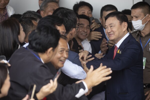 Thailand's former Prime Minister Thaksin Shinawatra, second right, is greeted by supporters on his arrival at Don Muang airport in Bangkok, Thailand, Tuesday, Aug. 22, 2023. (AP Photo/Wason Wanichakorn)