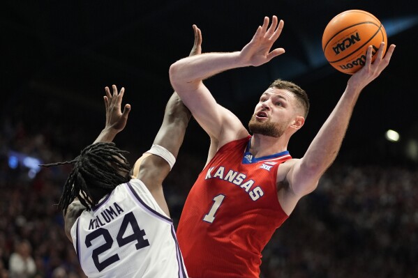 FILE - Kansas center Hunter Dickinson (1) shoots under pressure from Kansas State forward Arthur Kaluma (24) during the first half of an NCAA college basketball game Tuesday, March 5, 2024, in Lawrence, Kan. (AP Photo/Charlie Riedel, File)