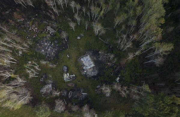 Two burnt cabins destroyed by wildfires, one belonging to Julia Cardinal, left, are visible near Fort Chipewyan, Canada, on Sunday, Sep. 3, 2023. Wildfires are bringing fresh scrutiny to Canada's fossil fuel dominance, its environmentally friendly image and the viability of becoming carbon neutral by 2050. (AP Photo/Victor R. Caivano)