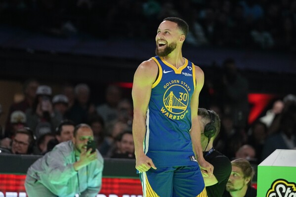 Golden State Warriors guard Stephen Curry reacts after winning a competition against Sabrina Ionescu at the NBA basketball All-Star weekend, Saturday, Feb. 17, 2024, in Indianapolis. (AP Photo/Darron Cummings)