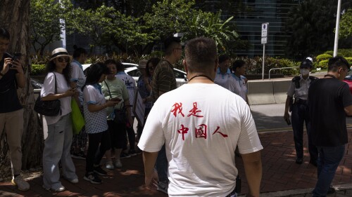 A pro-China protester leaves a mini protest with a shirt reading 
