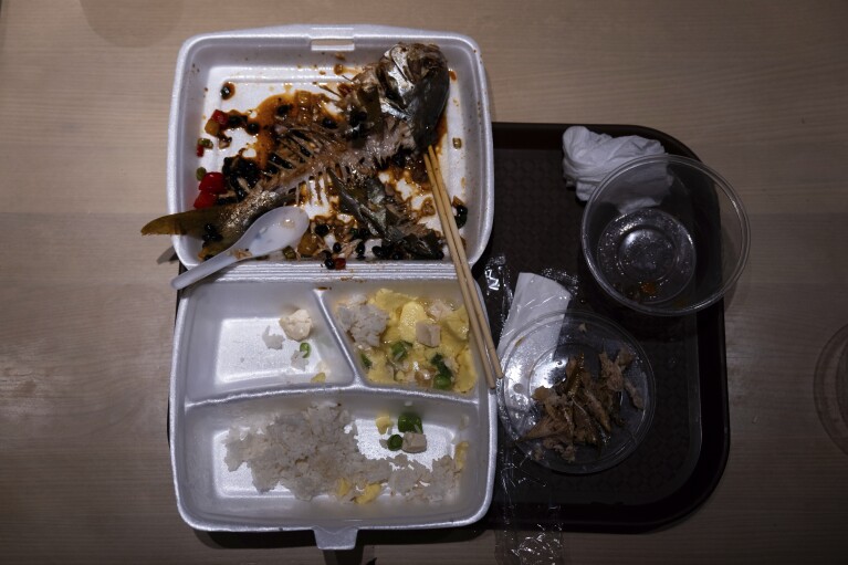 Leftover food in a plastic lunch box lies on the table of Kuen Fat Kitchen in Hong Kong, Wednesday, April 10, 2024. Hong Kong has long been a major producer and consumer of great food, and a great amount of plastic and Styrofoam to go with it. That’s going to change as new legislation aiming to stop the sale and distribution of Styrofoam products and single-use plastic cutlery went into effect on Monday, April 22, 2024.(AP Photo/Louise Delmotte)